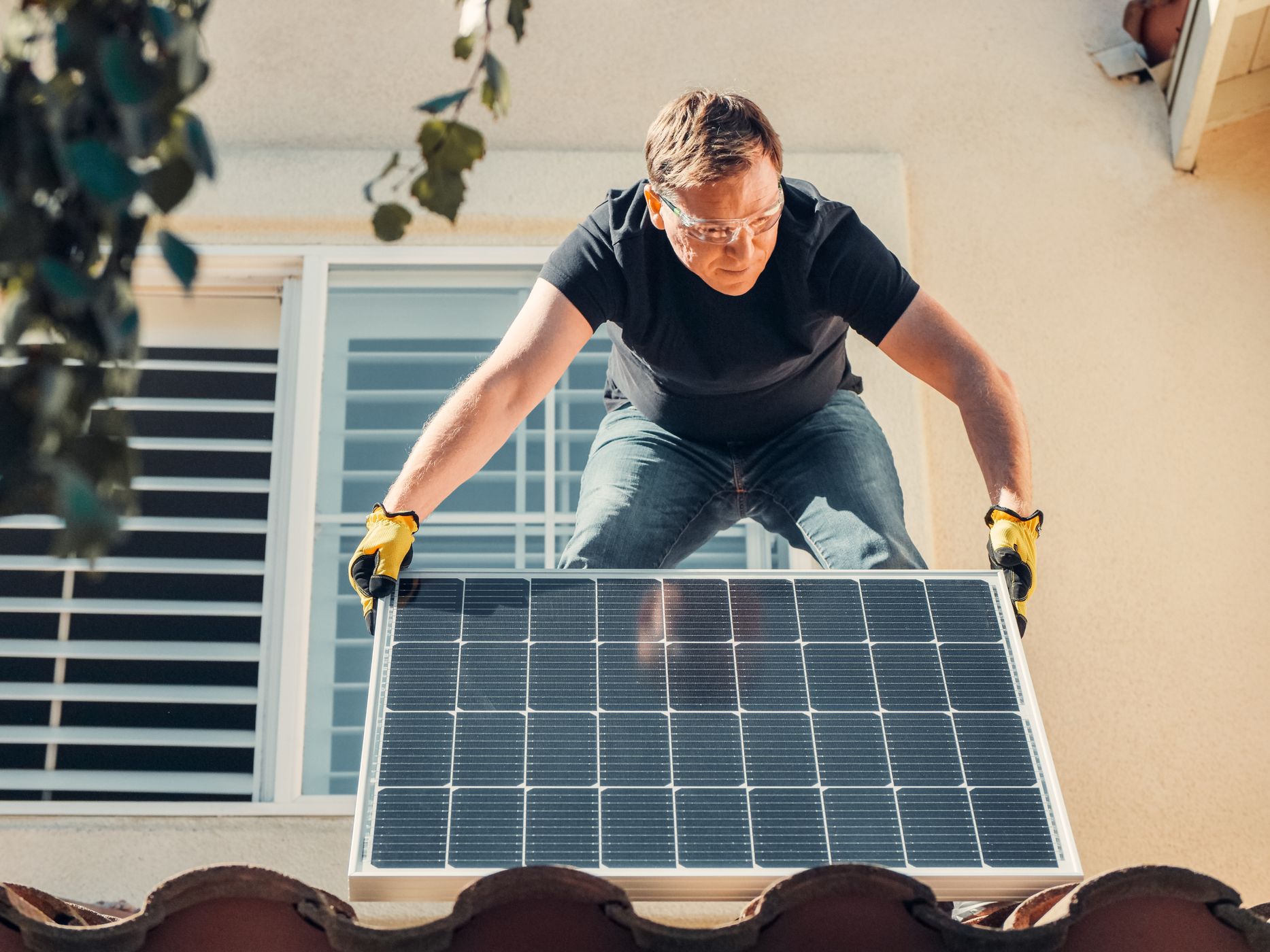 Techniker montiert eine Solarpanel-Anlage auf dem Dach